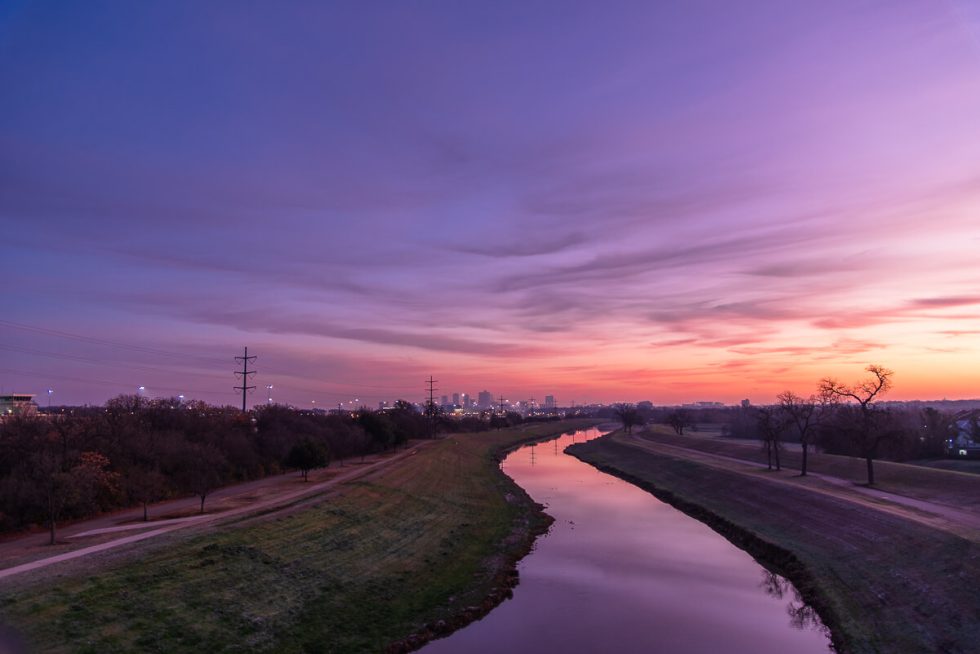 Fort Worth skyline at sunset with a creek